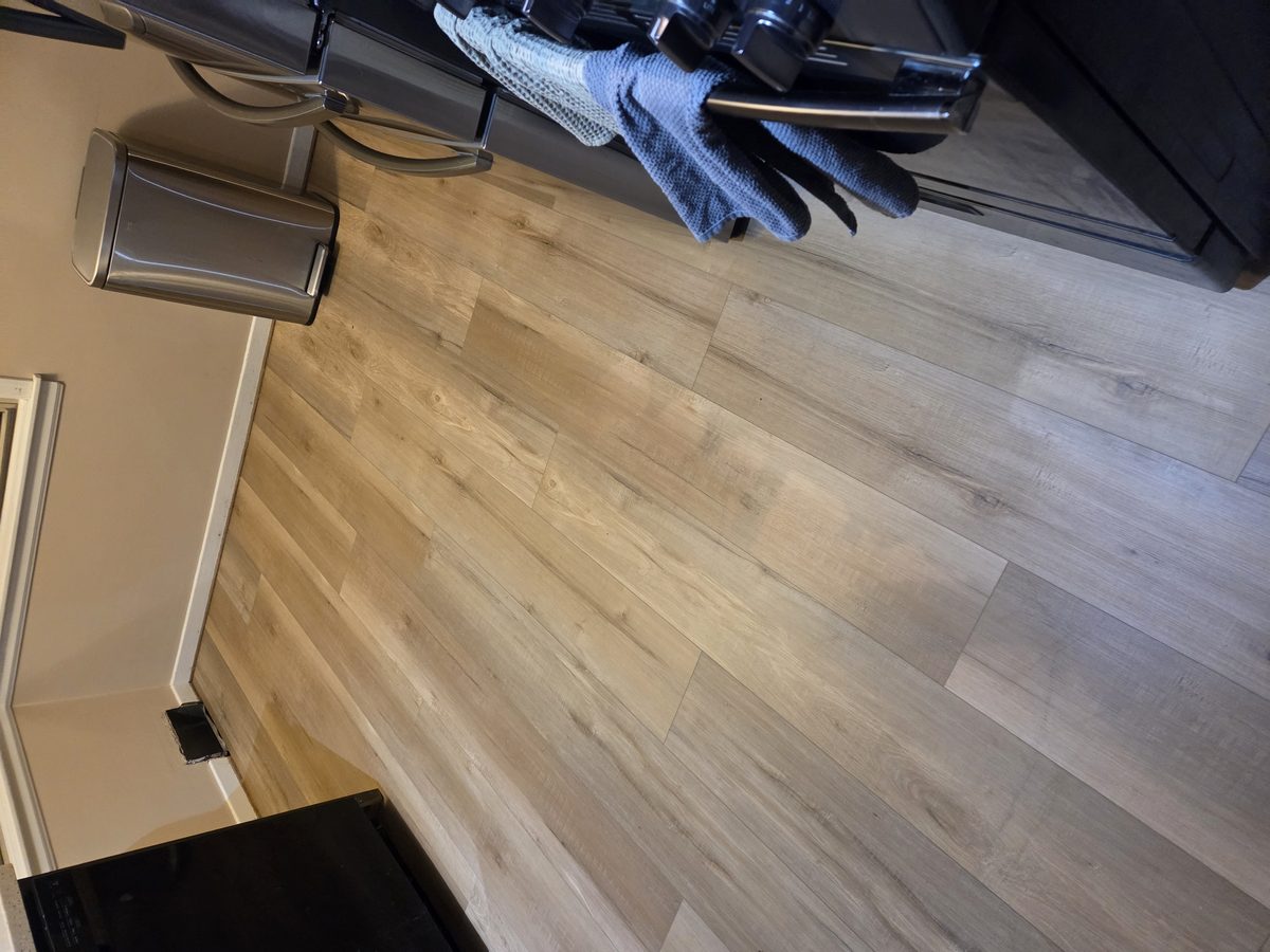 Kitchen floor after replacement with new plank flooring